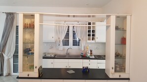 A kitchen with white cabinets, a black countertop, and a window with curtains. - Silver villa Raches, Green, Kite Surfers Spot (Raches, Fthiotida)