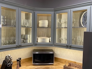 Kitchen area with microwave and unique cabinet display.