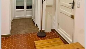 A hallway with a wooden bench, a coat rack, and a door with a handle. - Provencal loft with terrace in the heart of the village (salernes)