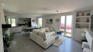 Un salon moderne comprenant un canapé, une table à manger et un coin cuisine.