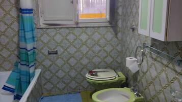 Een bad/douchecombinatie, een haardroger, een bidet, handdoeken
