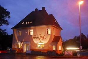 Un edificio de dos pisos con un letrero que dice 'Hotel Mama'.
