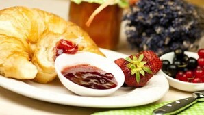 A plate with a croissant, strawberry, and berry compote. - Adam Hotel - Giesen (Giesen)