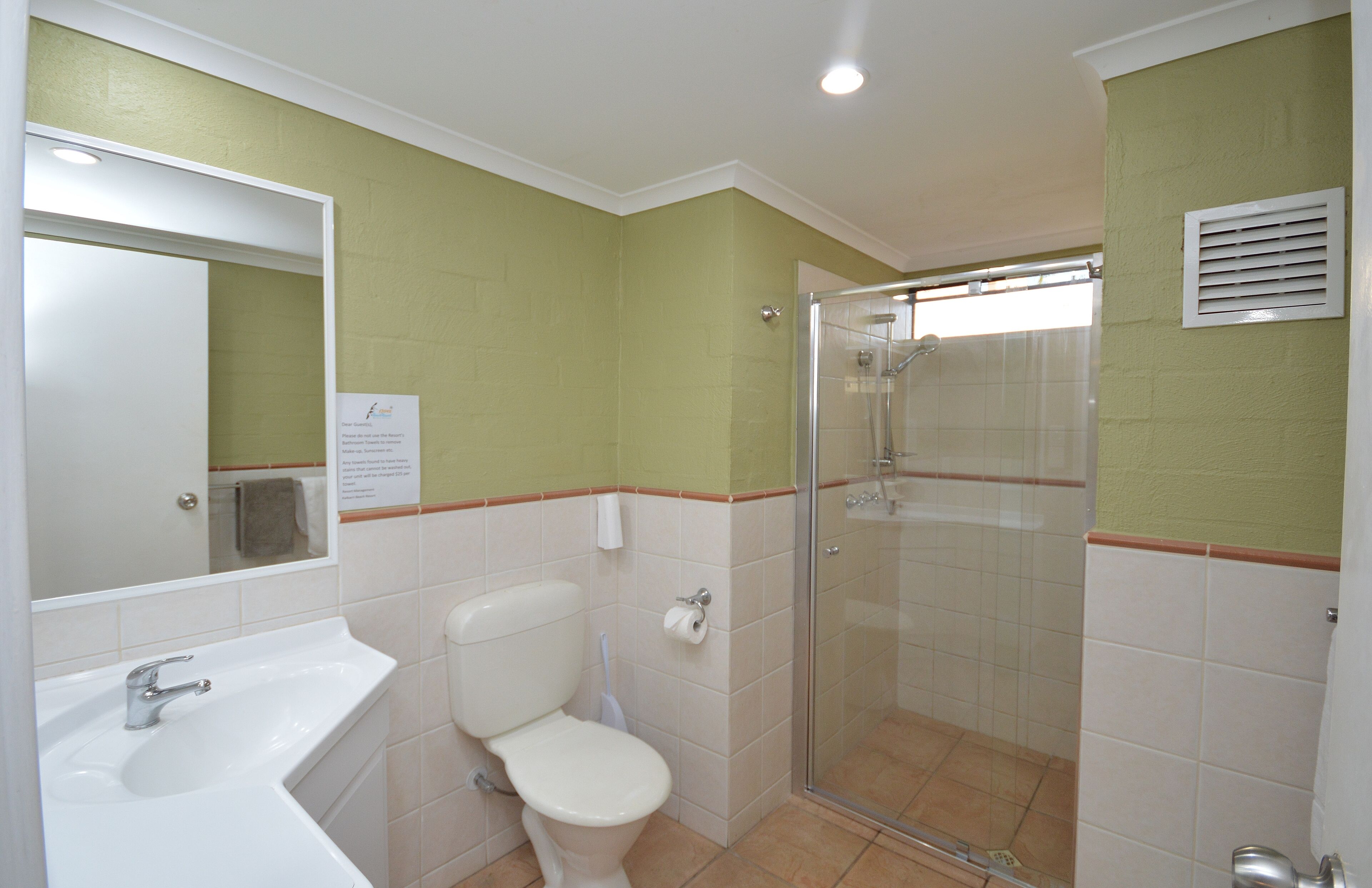 A bathroom with a sink, toilet, and glass-enclosed shower.