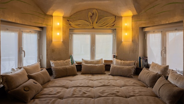 A large, centrally positioned bed with multiple pillows, flanked by windows with curtains, and wall-mounted lighting fixtures. - Villa Cerrado das Fontainhas (Sintra)