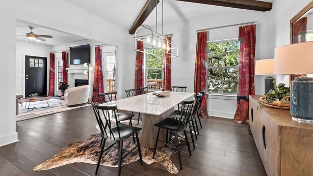 Un vaste espace dédié à la salle à manger, comprenant une grande table, des chaises et un ventilateur de plafond.