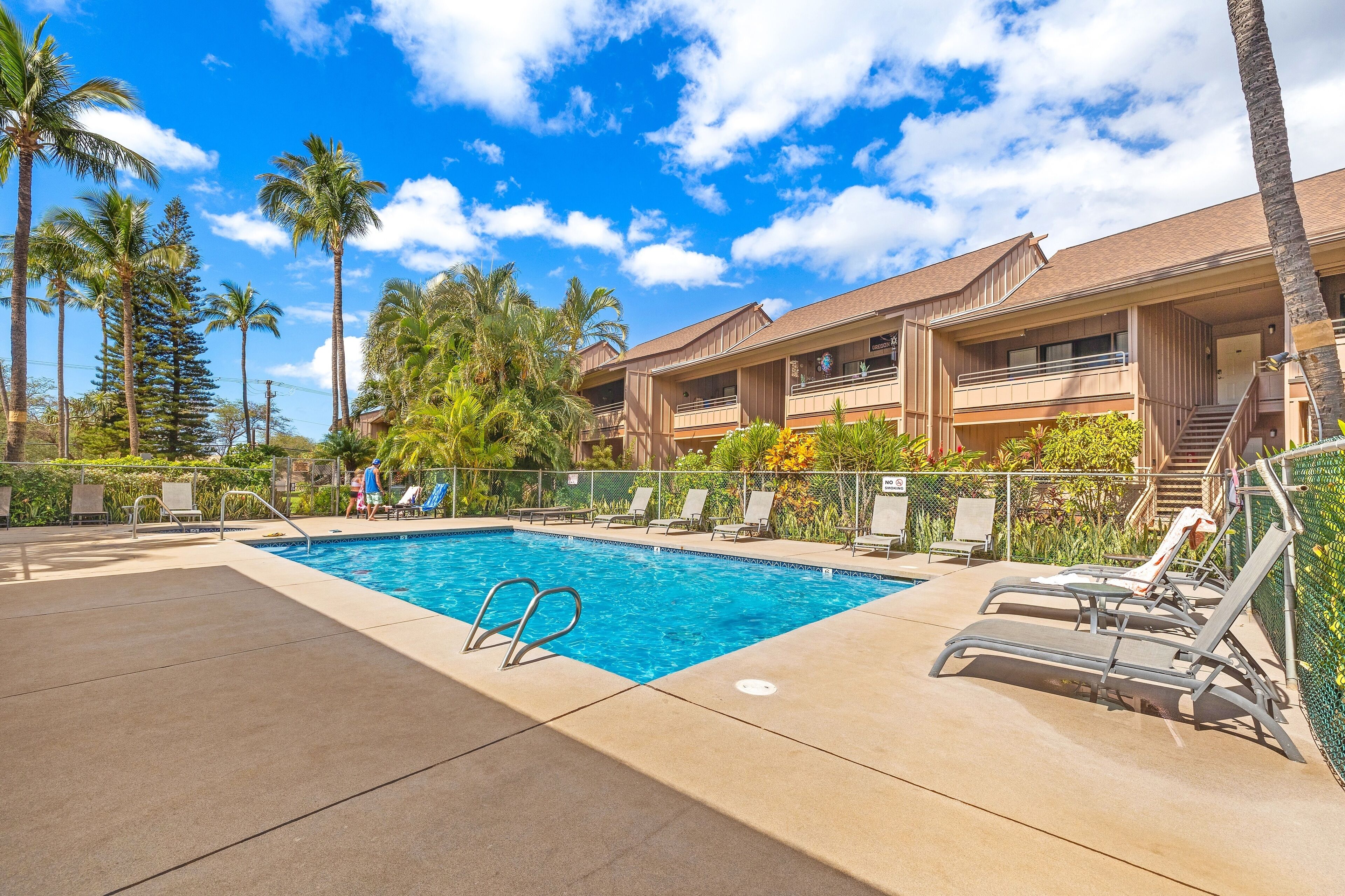 A swimming pool with lounge chairs and a staircase leading to a building.