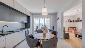 Et moderne køkken med spiseplads, store vinduer og udsigt til byen.