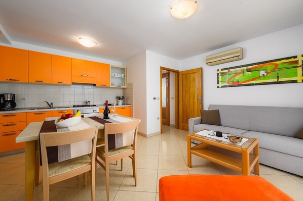 Un espace de vie compact comprenant une cuisine, un coin repas et un salon.