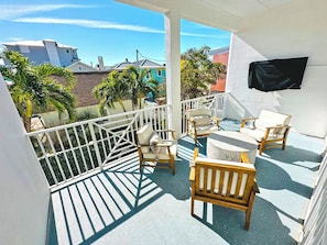 Enjoy the view from this balcony with a clear view of the surrounding neighborhood, featuring a comfortable seating area.