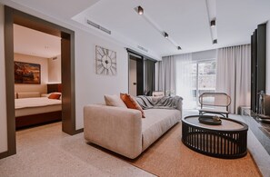 A modern living room with a sofa, a coffee table, and a painting on the wall.