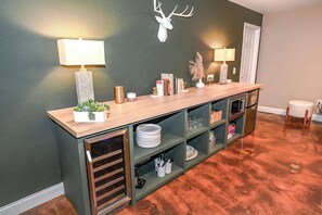 Uma cozinha com bancada de madeira, prateleiras e um chifre de veado decorativo na parede.