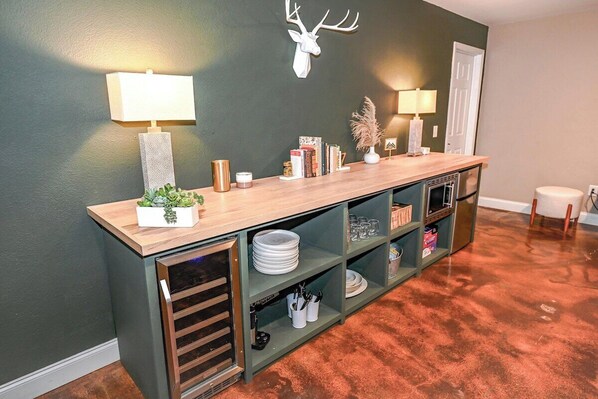A kitchen with a wooden countertop, shelves, and a wall-mounted deer head decoration. - Barefoot in the Blue Ridge (Hayesville)