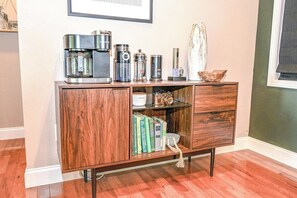 A wooden cabinet with a coffee maker, books, and decorative items. - Barefoot in the Blue Ridge (Hayesville)