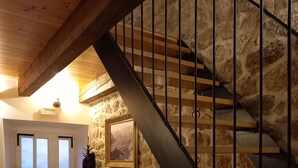 Eine Treppe mit einer Steinmauer, einer Bank und einer Tür mit satinierten Glasscheiben.