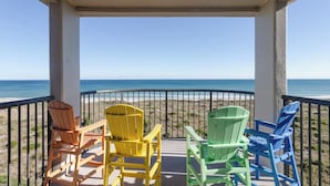 Ein Balkon mit Blick auf Strand und Meer.