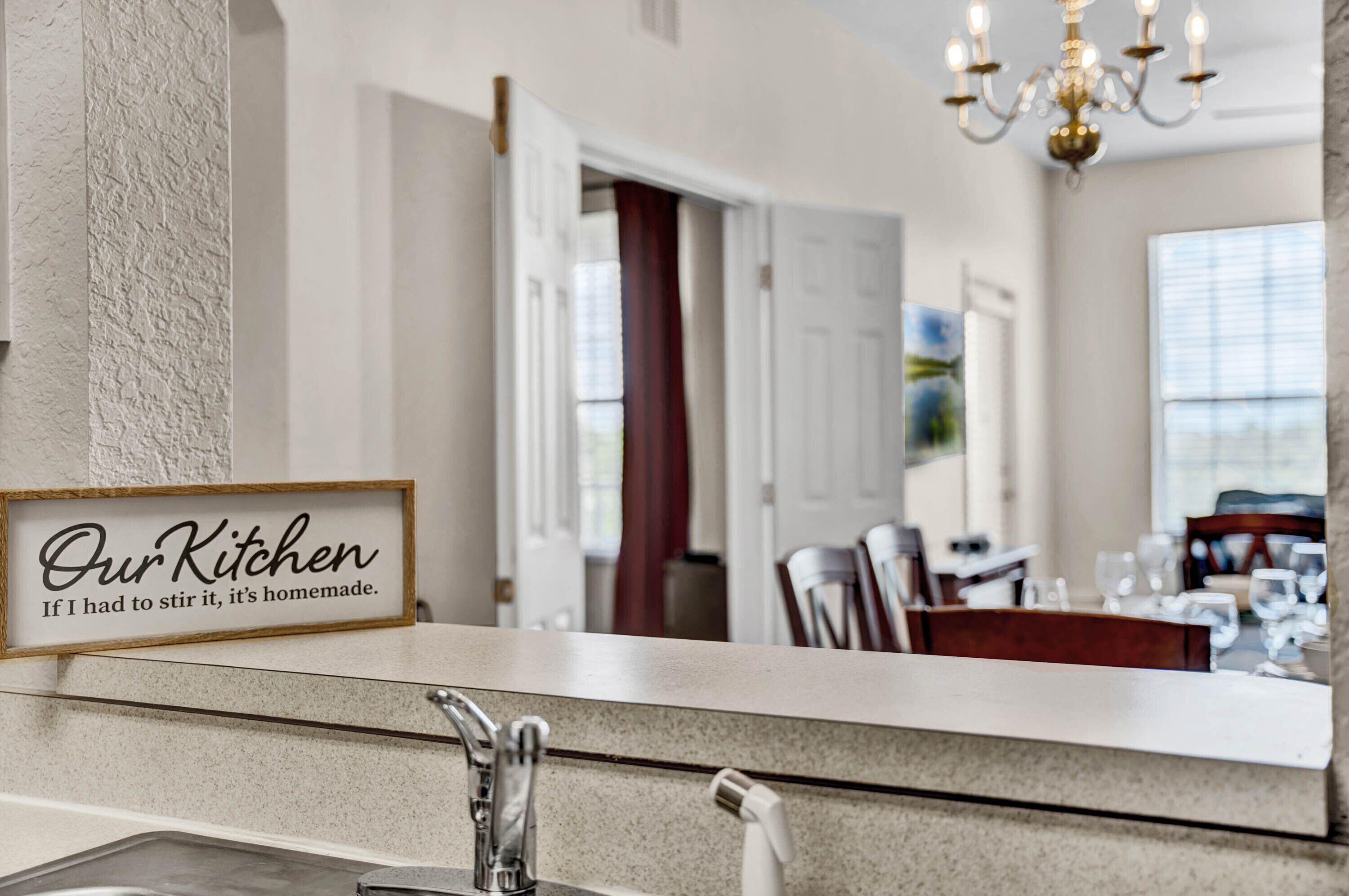A kitchen counter with a sign that reads 'Our Kitchen If I had to stir it, it's homemade.'