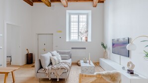 Una sala de estar moderna con un sofá, una mesa de centro, un televisor y una ventana con vistas.