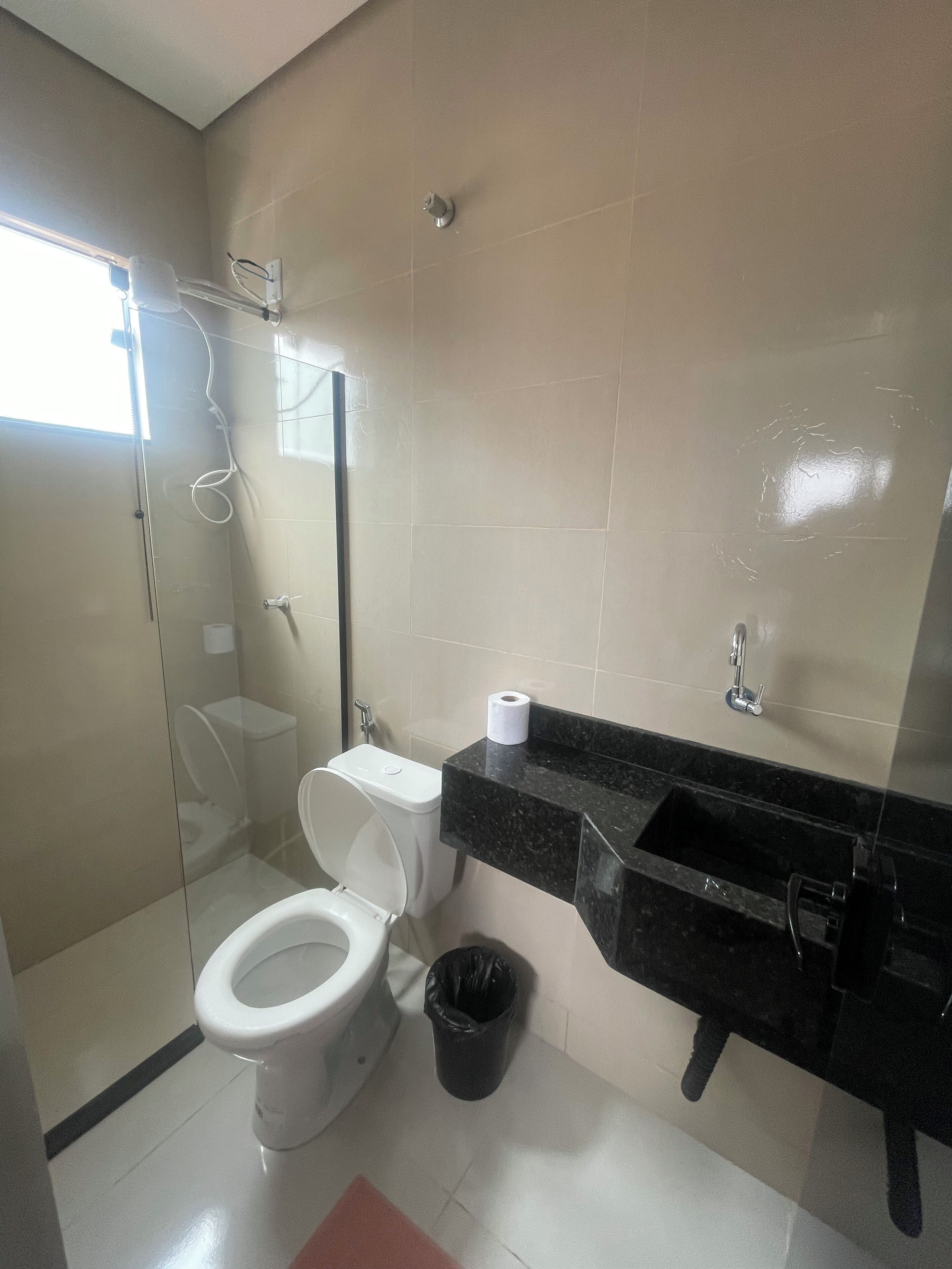 Une salle de bain avec des toilettes, une douche et un lavabo.