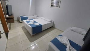 A hotel room with two beds, a television, and a painting on the wall. - Pousada Itaguaçu (Aparecida)