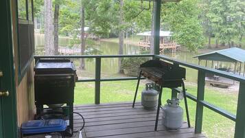 Enjoy al fresco dining with a grill and ceiling fan on this lakeside deck.
