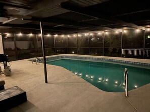 Una piscina con bordo piastrellato, circondata da una zona solarium con scalini che conducono in acqua.