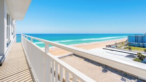 A balcony with a view of a beach and ocean.