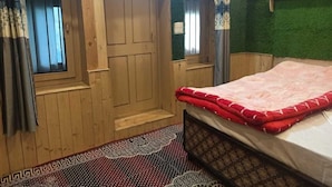 Une pièce en bois avec un lit, une fenêtre et une porte.