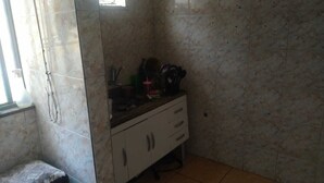 Una piccola cucina con schienale in marmo, un lavello e un piano di lavoro con diversi oggetti.