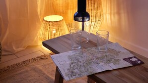 A wooden table with a map, two glass cups, and a lamp. - Design cottage in Drome Provençale (Vinsobres)
