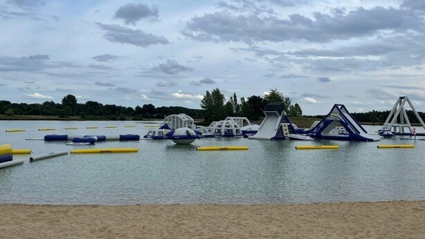 An outdoor water play area with various structures and floating toys.
