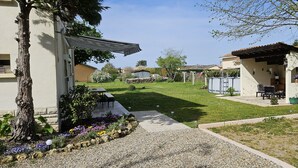A residential property with a well-maintained lawn, outdoor seating area, and a stone wall.