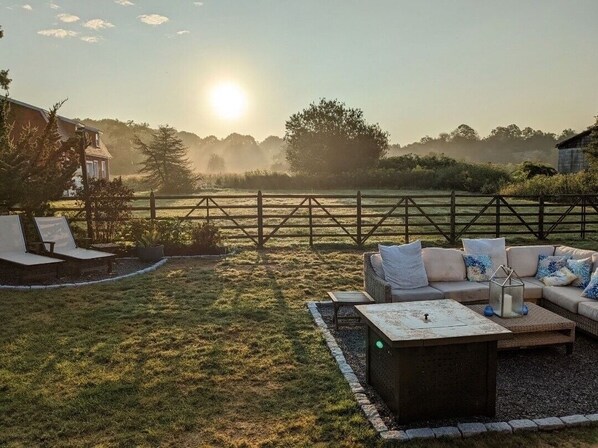 A patio with a sofa, a coffee table, and a small table with a candle.
