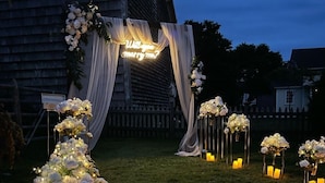 Une cérémonie de mariage en plein air, agrémentée de compositions florales et de bougies.