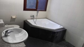Ein Badezimmer mit freistehender Badewanne, Waschbecken und Toilette.