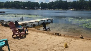 Ein Strand mit einer Mole, Stühlen und einem Sandbereich.