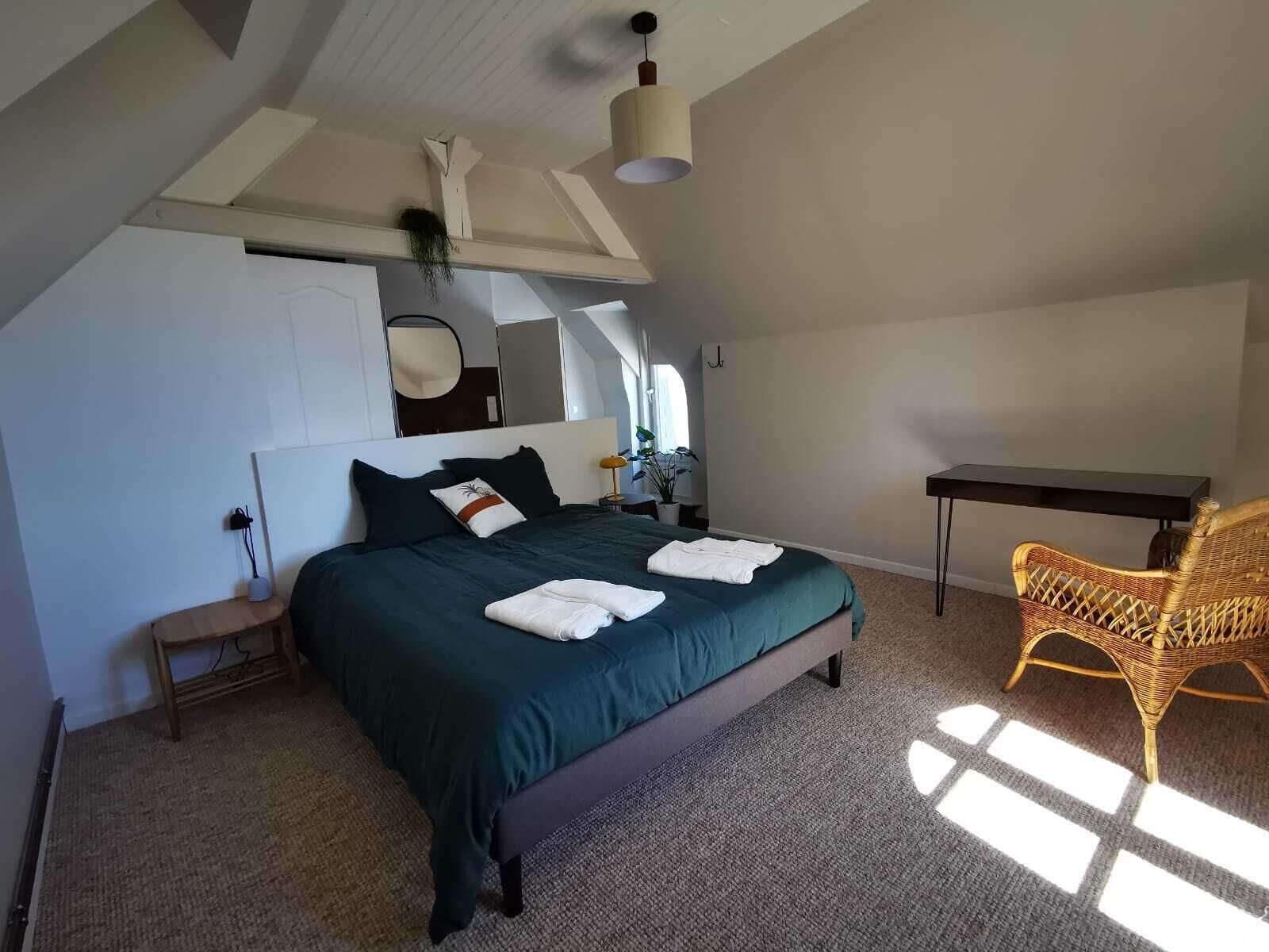 Une chambre à coucher comprenant un lit, une table de chevet, une chaise et un bureau.
