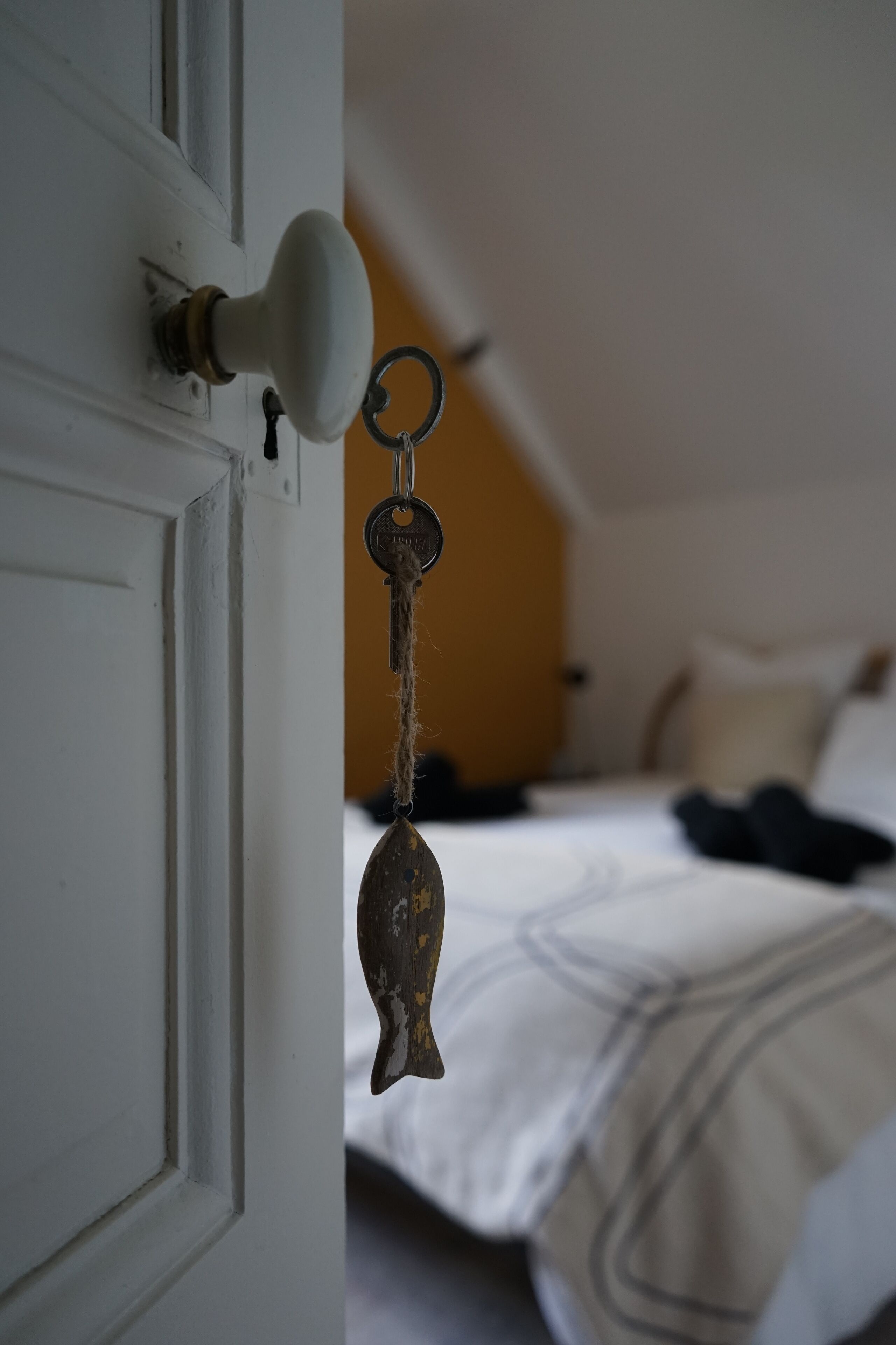 A white door with a keyhole and a keychain hanging on it.