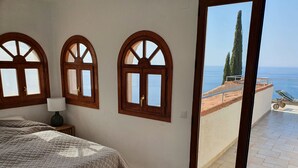 A bedroom with a large window, a bed, and a nightstand. - Exclusive villa with private pool and gym (Almuñécar)