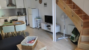 Eine moderne Wohnung mit Küche, Essbereich, Wohnzimmer und einer Holztreppe.