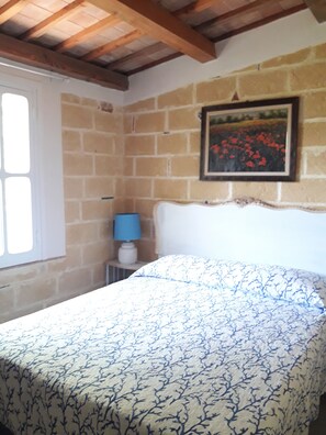 A bedroom with a bed, a window, a lamp, and a picture on the wall. - Villa located two kilometers from the kitesurfing schools (MARSALA)