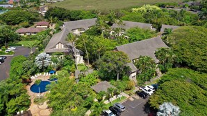 A residential area with houses, a swimming pool, and a view of the ocean. - Waikomo Stream Villas 302 | Updated 1BR Condo w/ Cal King, AC, Murphy Bed (Koloa)
