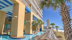 Un hôtel doté d’une piscine, de palmiers et offrant une vue sur la plage.