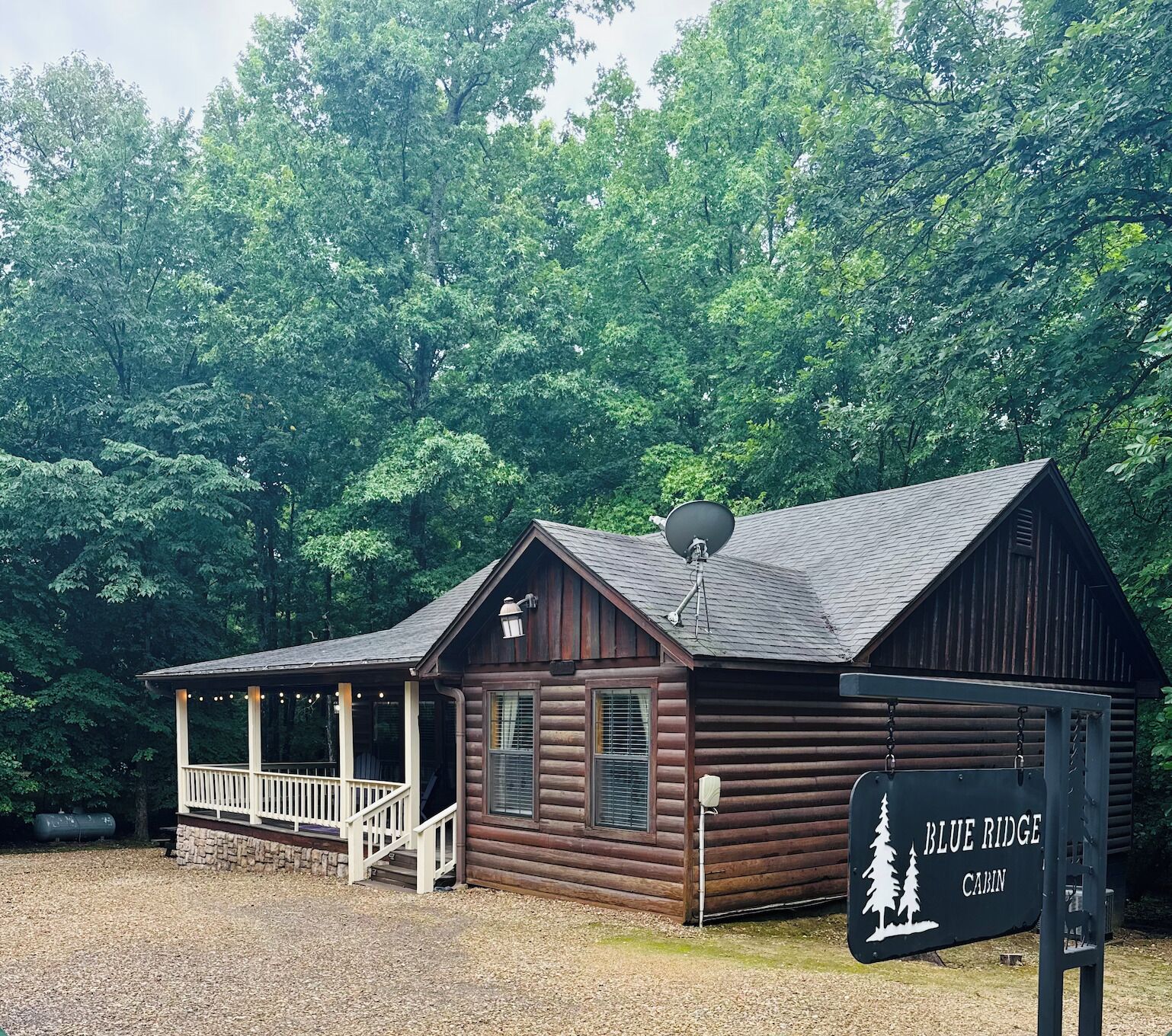 Une cabane en rondins avec un porche et une pancarte indiquant « Blue Ridge Cabin ».