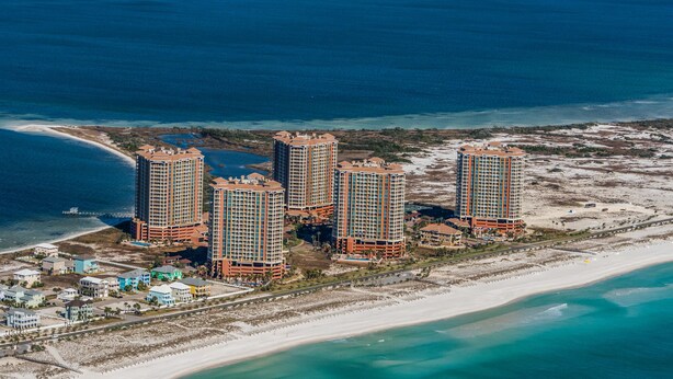 Un complexe hôtelier de grande hauteur comprenant plusieurs bâtiments, une plage et un port de plaisance.