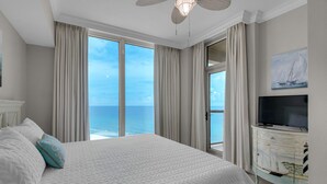 Une chambre avec un grand lit, une télévision et une vue sur l’océan.