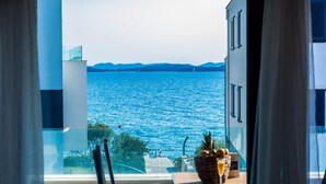 A balcony with a table, chairs, and a view of the sea. - Crystal Holiday Residence (Sukosan)