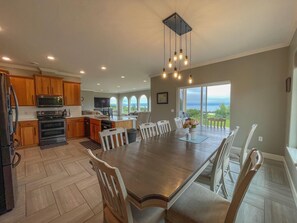 Una cocina amplia con armarios de madera, una isla grande y un comedor con vistas al exterior.