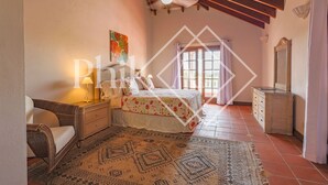 A bedroom with a bed, a nightstand, a dresser, a chair, a ceiling fan, and a window with curtains. - Beautiful 5 bed-rooms Villa at Terres Basses (Saint Martin)