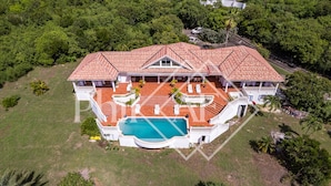 An aerial view of a large house with a swimming pool, surrounded by lush greenery. - Beautiful 5 bed-rooms Villa at Terres Basses (Saint Martin)